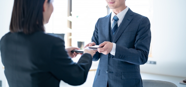 名刺交換する男女